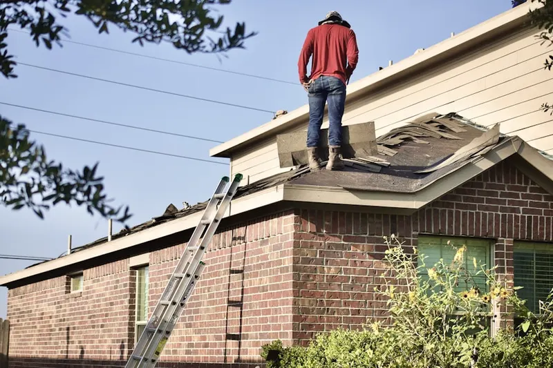 Professional roofer working on a residential roof in Stow